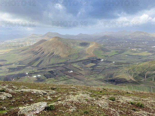 View of Montaña Tesa volcano from Montaña Blanca mountain with cloudy sky, Lanzarote, Canary