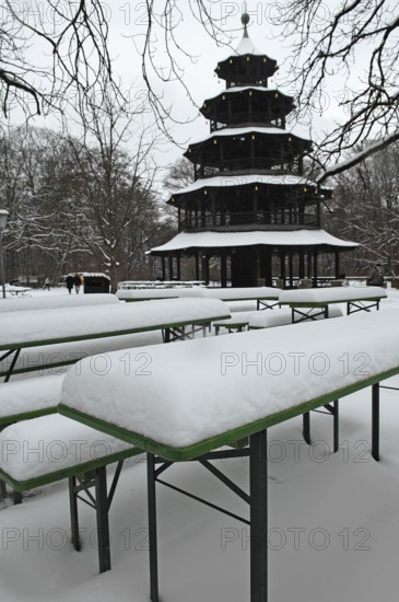 Winter in the English Garden, snow-covered beer garden tables and benches, Chinese Tower, Munich,