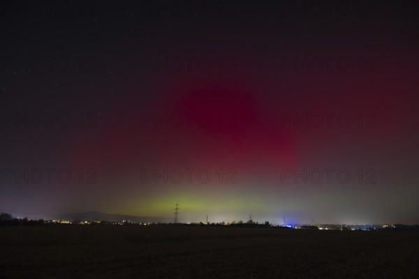 Northern lights (aurora borealis) glow red and green in the evening sky over Germany, Frankfurt am