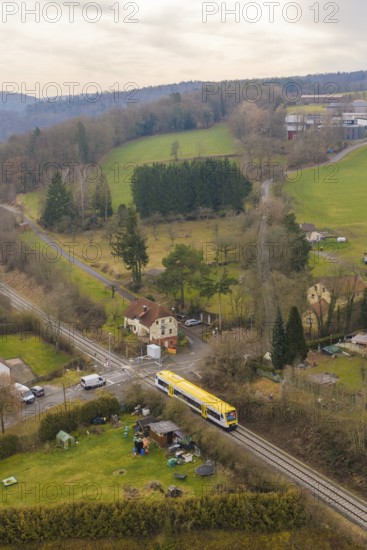 Rural scene with yellow train in green countryside and scattered houses, acceptance of the Hermann