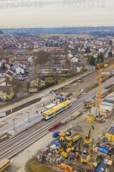 Aerial view of a city with a construction site and a yellow train on the tracks, construction