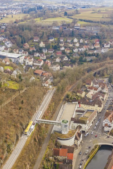 Panorama of city with railroad tracks, hills and river, surrounded by dense residential