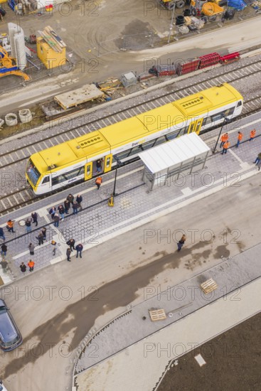 Bird's eye view of yellow train on a busy platform, taking off the Hermann Hesse Railway, Calw,