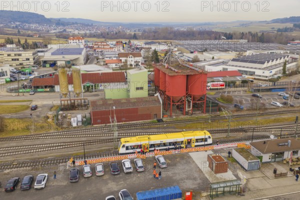Aerial view of an industrial area with yellow train and large building structures, acceptance of