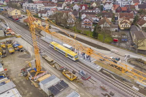 Aerial view of a yellow train on a construction site, crane and workers during construction, the
