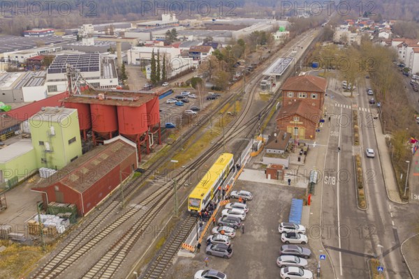 Industrial area with train station and train, surrounded by factories and buildings, shows urban