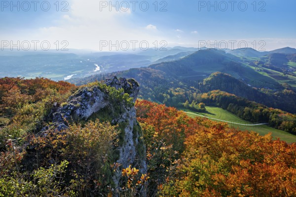 View from the Gisliflue of an autumn-colored forest, behind the Jurassic foothills with water fluh