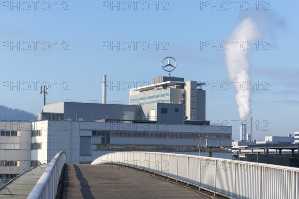Building with Mercedes logo and rising steam in the background under a clear sky, Mercedes star,