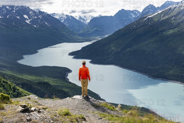 Mountaineer enjoys views of blue lake and mountains on Twin Peaks Trail, Eklutna Lake, Chugach