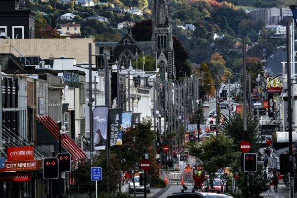 Lively shopping street with historic buildings and hills in the background in Dunedin, Dunedin,