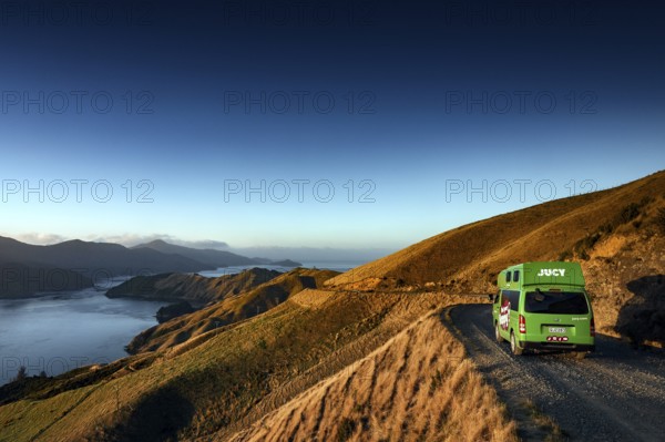 Camper drives along picturesque French Pass Road overlooking a sound, French Pass Road, South
