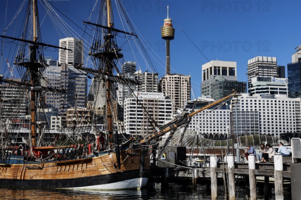 Historic sailing ship in Darling Harbour in front of a modern skyline under blue sky, Sydney, New