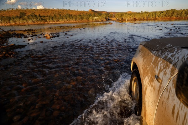 A vehicle crosses the Pentecost River through a shallow ford when the sun is low, Pentecost River,