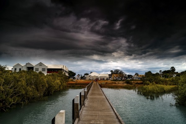 Streeters Jetty in Broome with dramatic clouds over coastal landscape, Broome, Western Australia,