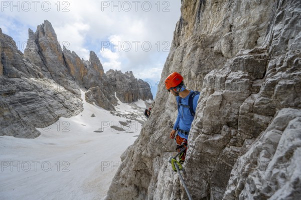 Mountaineer climbs on a steep rock face in the Via Ferrata dell'Ideale via ferrata, spectacular