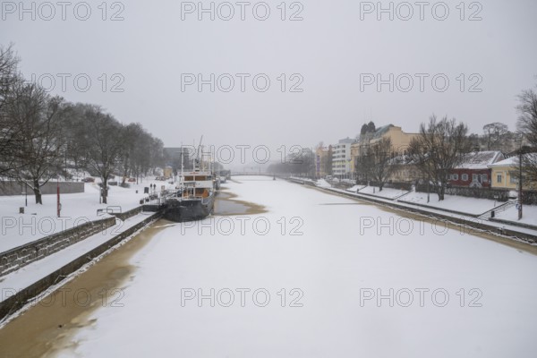Ships moored on the banks of the frozen Aurajoki River, wintery Turku or Swedish Åbo,