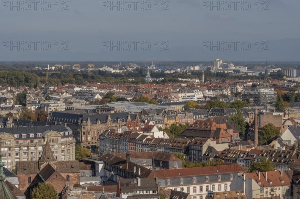 The stone balcony offers a view of the city of Strasbourg. Houses and buildings can be seen under a
