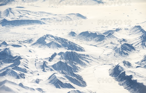 Icy, snowy arctic mountain landscape with glaciers, aerial view, Greenland, Arctic