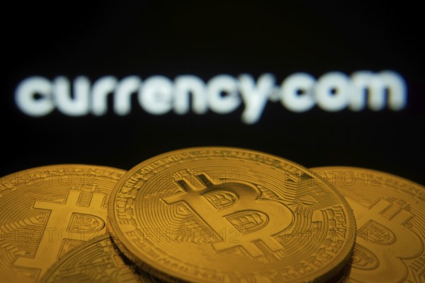 Dhaka, Bangladesh- 22 June 2025: Close-up of Bitcoin coins with the Currency.com logo visible on a