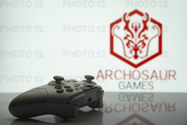 Dhaka, Bangladesh- 20 Mar 2025: A close-up of a white gamepad with the ARCHOSAUR GAMES seen on