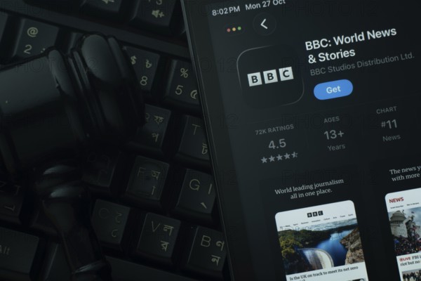 Dhaka, Bangladesh- 28 Oct 2025: An iPad displaying the BBC app against a judge's gavel and dark