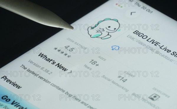 Dhaka, Bangladesh- 30 Oct 2025: Bigo Live app on a iPad screen with a pen pointing at the install