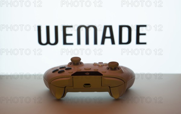 Dhaka, Bangladesh- 14 Nov 2025: A close-up of a white gamepad with the WeMade Entertainment seen on