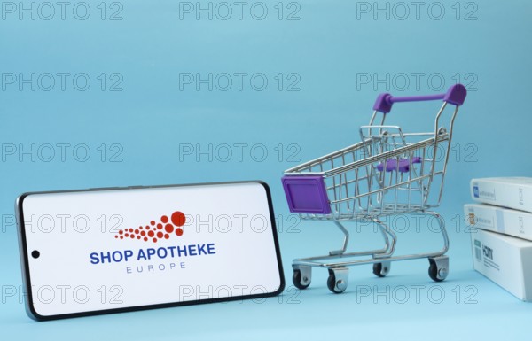 Dhaka, Bangladesh- 21 Nov 2025: Smartphone with Shop Apotheke logo next to a small shopping cart