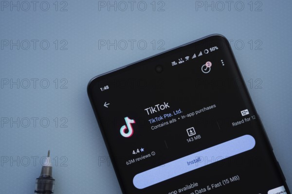 Dhaka, Bangladesh- 29 May 2025: On a blue surface, a smartphone displays the TikTok app within the