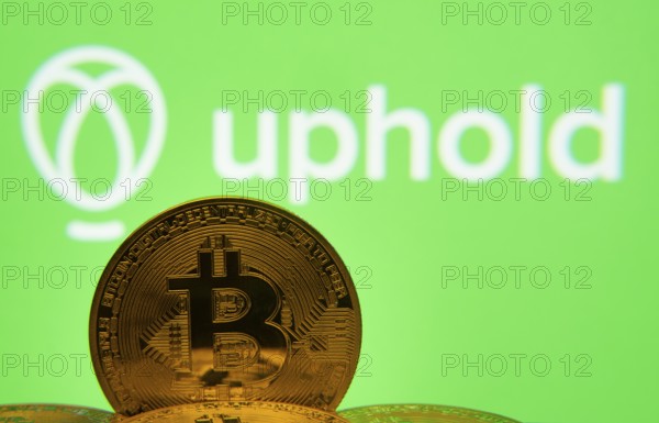 Dhaka, Bangladesh- 19 Sep 2025: Close-up of Bitcoin coins with the Uphold logo visible on a screen