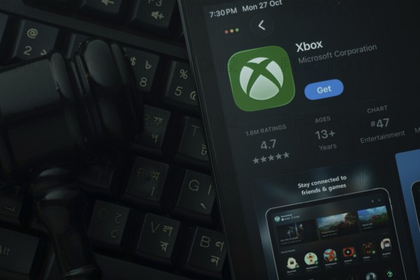Dhaka, Bangladesh- 28 Oct 2025: An iPad displaying the Xbox app against a judge's gavel and dark