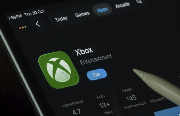 Dhaka, Bangladesh- 30 Oct 2025: Xbox app displayed on a iPad screen in dark mode with a digital pen