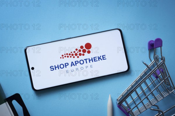 Dhaka, Bangladesh- 03 July 2025: Smartphone displaying (...) logo with shopping cart on a blue