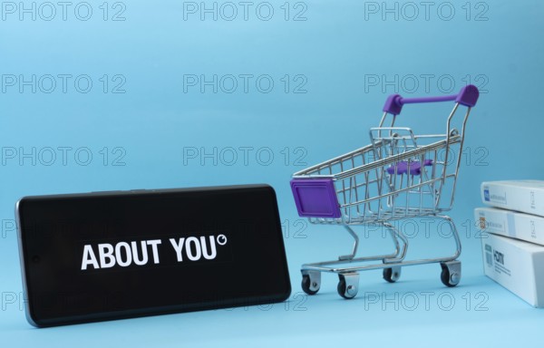 Dhaka, Bangladesh- 21 Nov 2025: Smartphone with About You logo next to a small shopping cart and