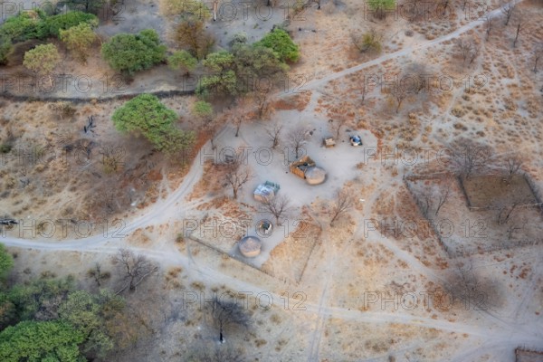 Settlement, simple house and fence, dry savanna landscape, near Maun, aerial view, Okavango Delta,