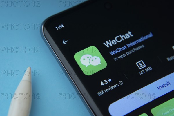 Dhaka, Bangladesh- 29 May 2025: On a blue surface, a smartphone displays the WeChat app within the