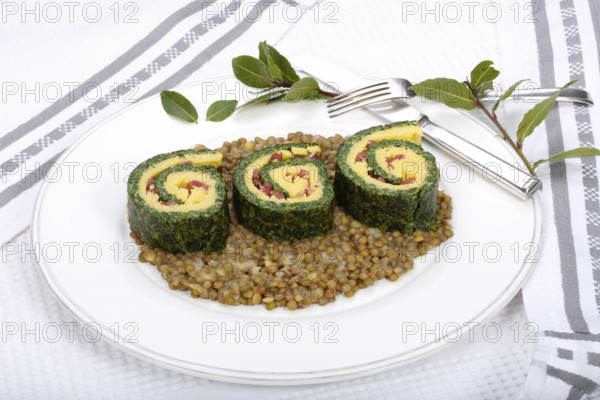 Southern German cuisine, polenta spinach roulade with alblentils served on serving platter, bay