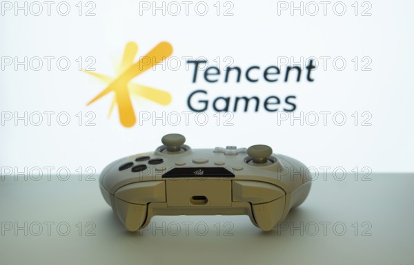 Dhaka, Bangladesh- 14 Nov 2025: A close-up of a white gamepad with the Tencent Games seen on screen