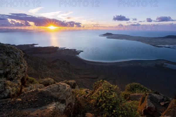 View from steep cliffs to sea and coast with sun stars, Mirador del Porrito viewpoint at sunset,