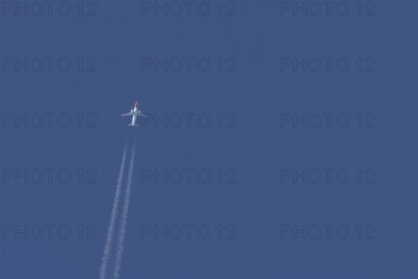 Boeing 737 jet passenger aircraft of Norwegian Air airlines flying in a blue sky with contrails or