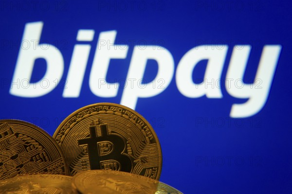 Dhaka, Bangladesh- 26 Aug 2025: Close-up of Bitcoin coins with the bitpay logo visible on a screen