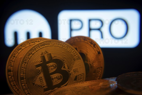 Dhaka, Bangladesh- 01 Nov 2025: Close-up of Bitcoin coins with the Kraken Pro logo visible on a