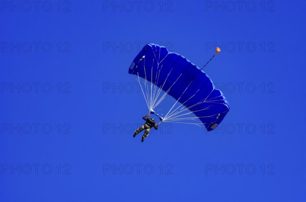Skydivers during an aerial acrobatic performance as part of an air show at the Fliegerbergfest of