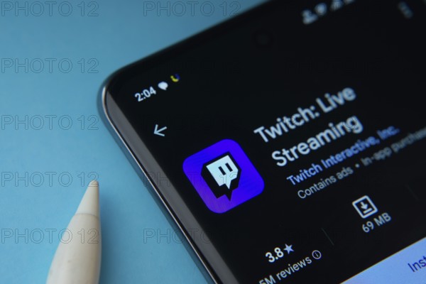 Dhaka, Bangladesh- 30 Sep 2025: On a blue surface, a smartphone displays the Twitch app within the