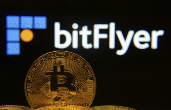Dhaka, Bangladesh- 02 June 2025: Close-up of Bitcoin coins with the Bitflyer logo visible on a