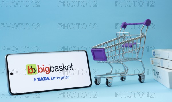 Dhaka, Bangladesh- 03 July 2025: Smartphone with BigBasket logo next to a small shopping cart and