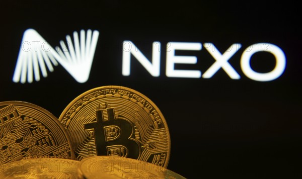 Dhaka, Bangladesh- 06 Sep 2025: Close-up of Bitcoin coins with the Nexo logo visible on a screen in