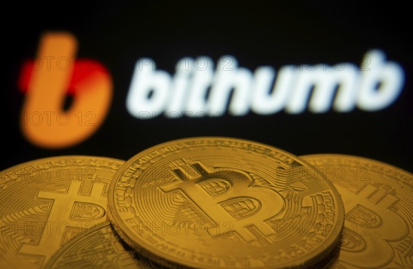 Dhaka, Bangladesh- 07 May 2025: Close-up of Bitcoin coins with the Bithumb logo visible on a screen