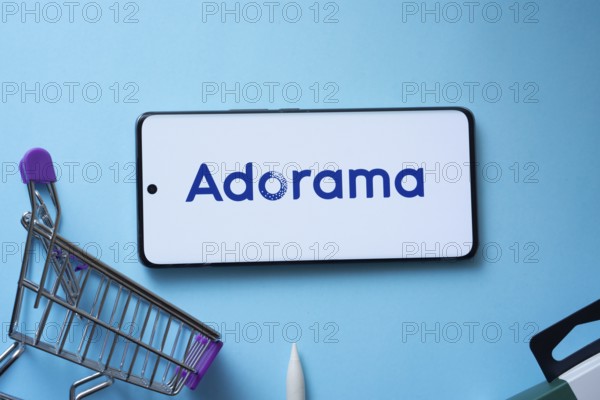 Dhaka, Bangladesh- 03 July 2025: Smartphone displaying Adorama logo with shopping cart on a blue