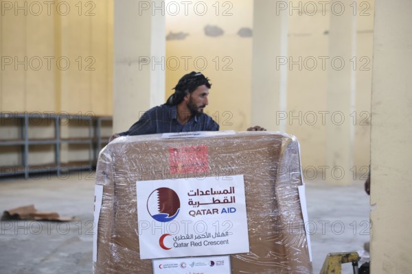 Relief workers unload boxes of medical aid provided by Qatar at Damascus International Airport,